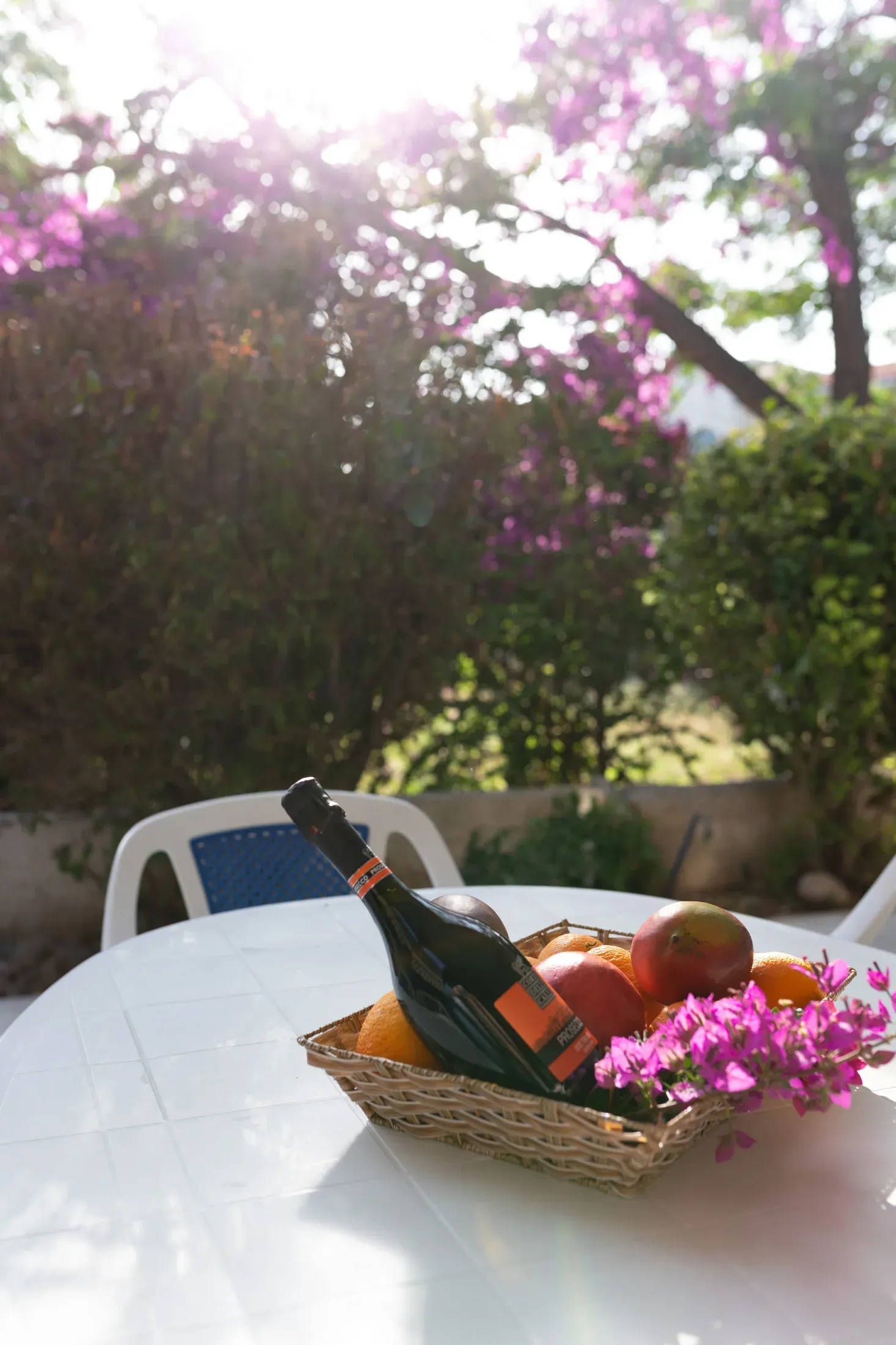 A fruit basket and a bottle of prosecco waiting on the patio table