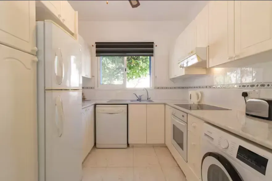 The kitchen at Villa Nadezda with oven, dishwasher and a window onto the garden