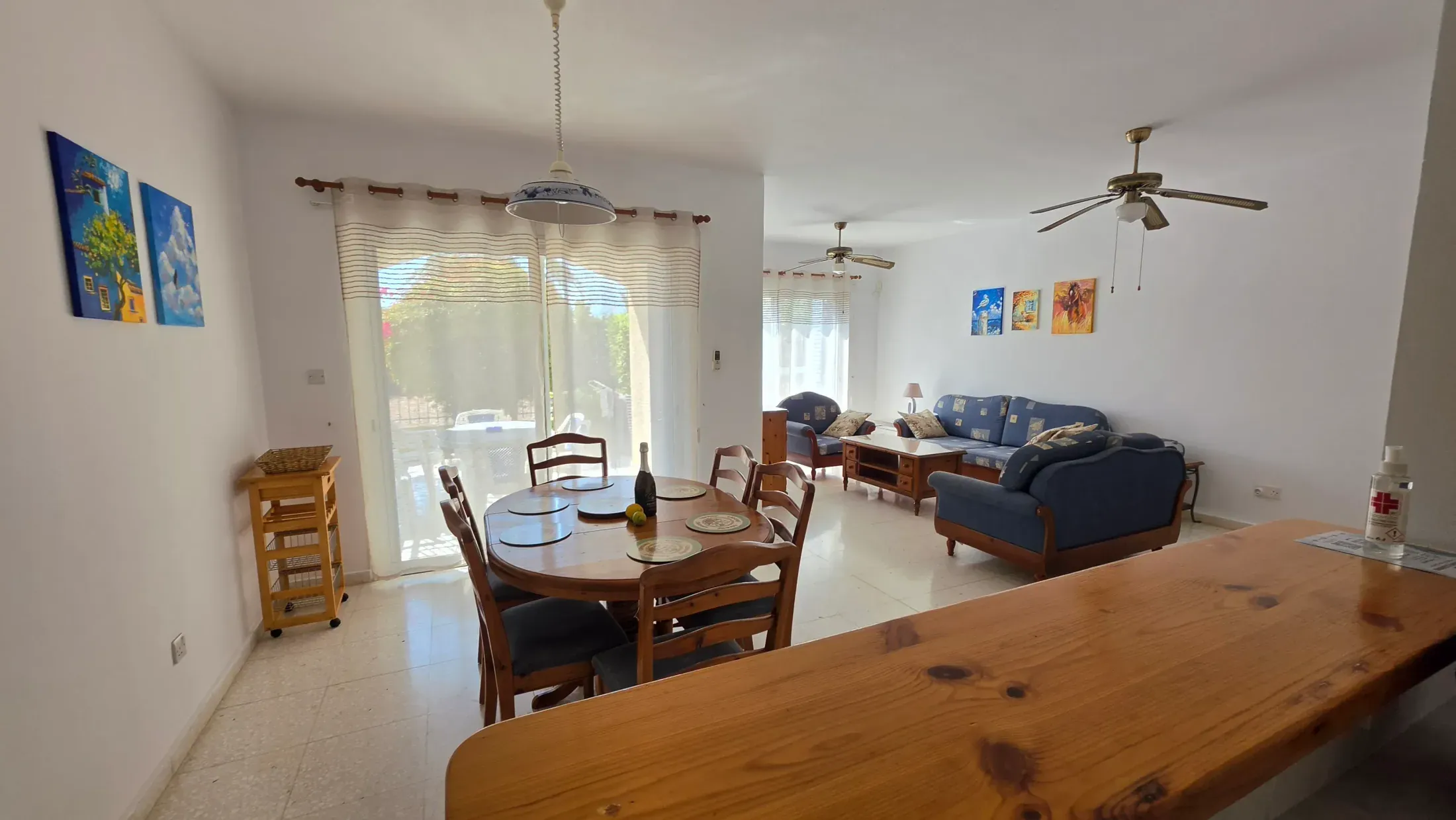 Open-plan dining and living area at Villa Nadezda with solid pine furniture and hand-painted canvases